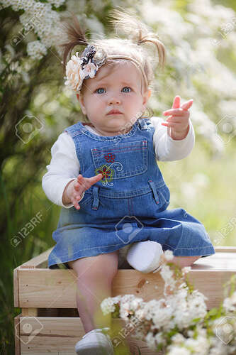 Portrait Of A Beautiful Little Girl 1 Year Old With Blue-gray Emerald Eyes  In A