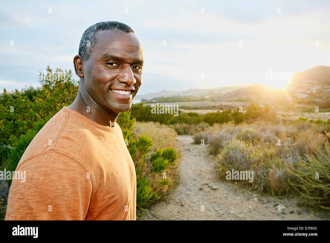 black-man-smiling-on-rural-hillside-E7F8XC
