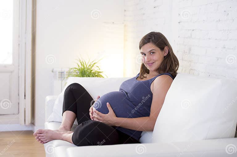 young-beautiful-happy-months-pregnant-woman-home-living-room-couch-holding-big-belly-sitting-her-hands-pregnancy-73425681